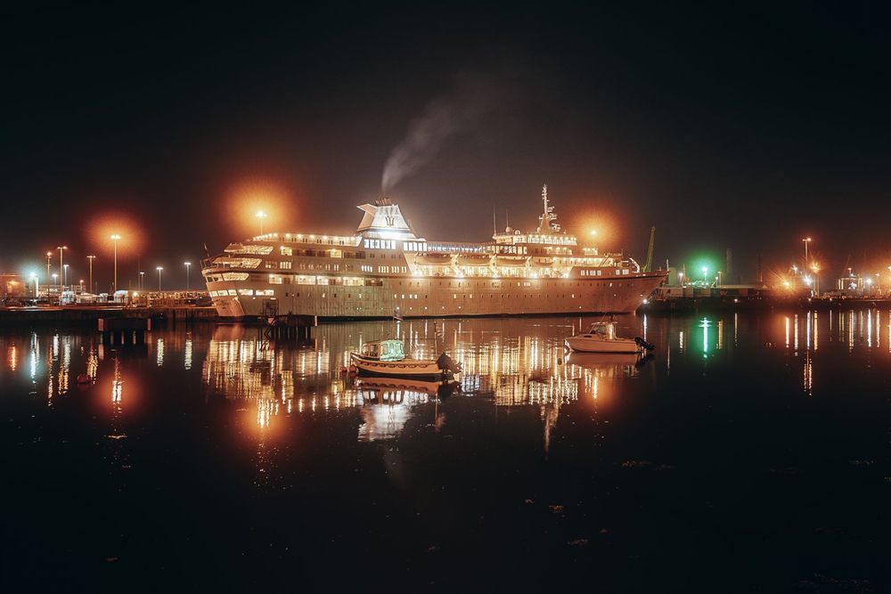 Cruise ship glowing with lights in a harbor at night